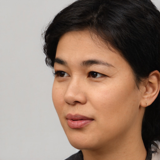 Joyful asian young-adult female with medium  black hair and brown eyes