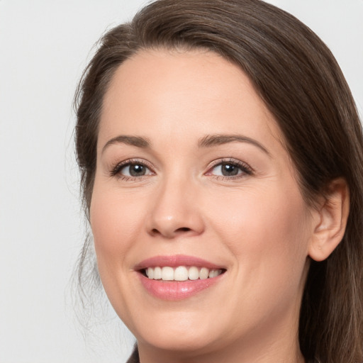 Joyful white young-adult female with long  brown hair and brown eyes