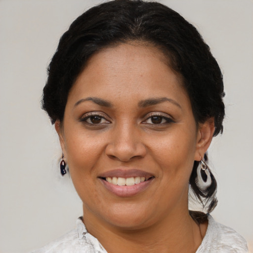 Joyful latino adult female with medium  brown hair and brown eyes