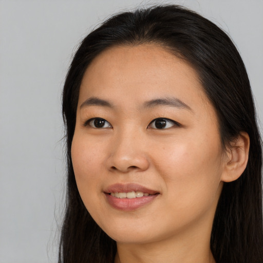 Joyful asian young-adult female with long  black hair and brown eyes
