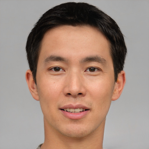 Joyful asian young-adult male with short  black hair and brown eyes