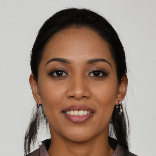 Joyful latino young-adult female with long  black hair and brown eyes