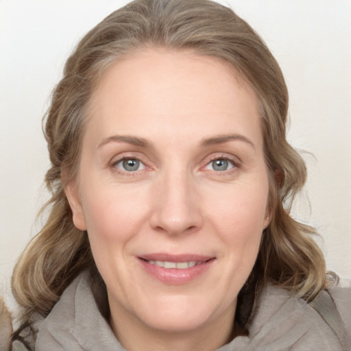 Joyful white adult female with medium  brown hair and grey eyes