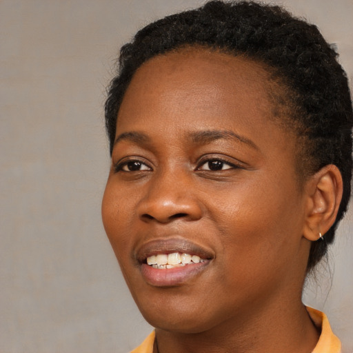 Joyful black young-adult female with short  brown hair and brown eyes