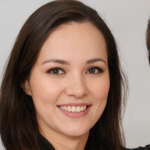 Joyful white young-adult female with long  brown hair and brown eyes