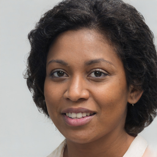Joyful black young-adult female with long  brown hair and brown eyes