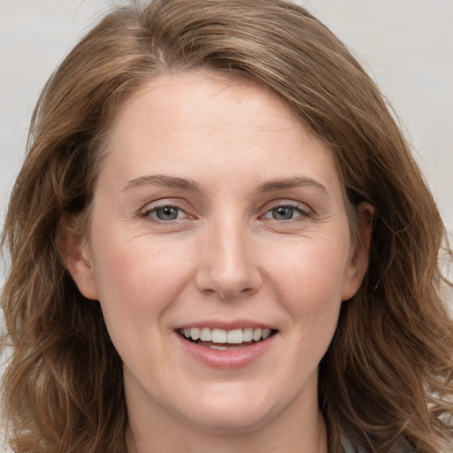 Joyful white young-adult female with long  brown hair and grey eyes