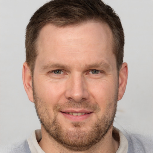 Joyful white adult male with short  brown hair and brown eyes