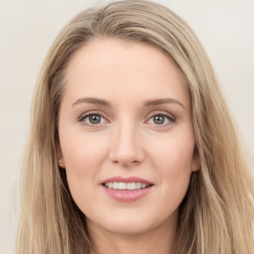 Joyful white young-adult female with long  brown hair and blue eyes