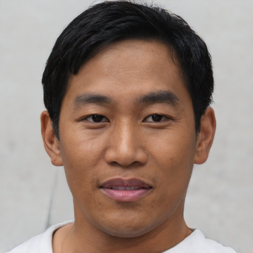 Joyful asian young-adult male with short  black hair and brown eyes