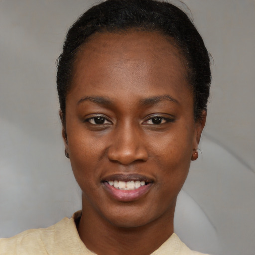 Joyful black young-adult female with short  black hair and brown eyes