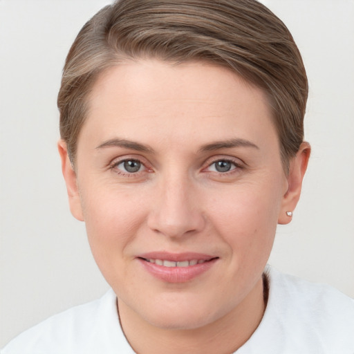 Joyful white young-adult female with short  brown hair and grey eyes