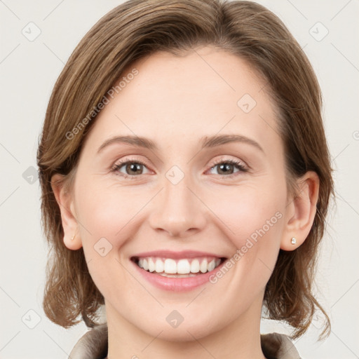 Joyful white young-adult female with medium  brown hair and green eyes