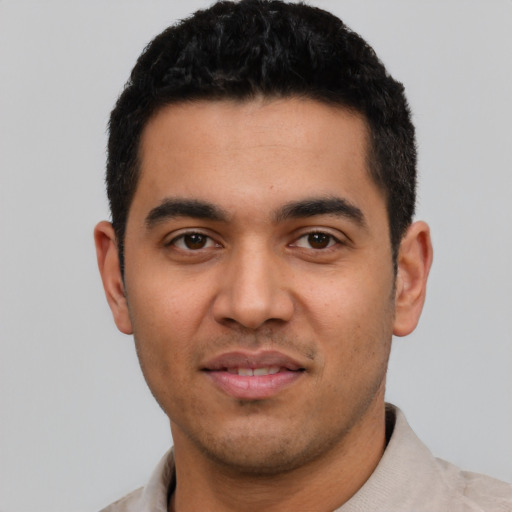 Joyful latino young-adult male with short  black hair and brown eyes