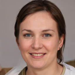 Joyful white adult female with medium  brown hair and grey eyes