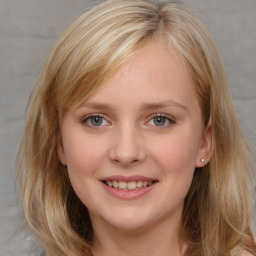 Joyful white young-adult female with long  brown hair and blue eyes