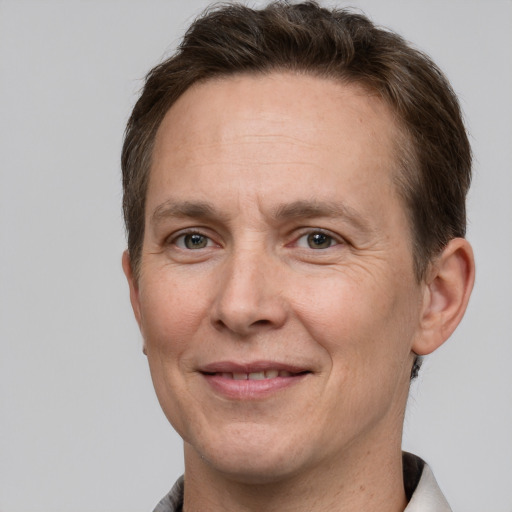 Joyful white adult male with short  brown hair and grey eyes