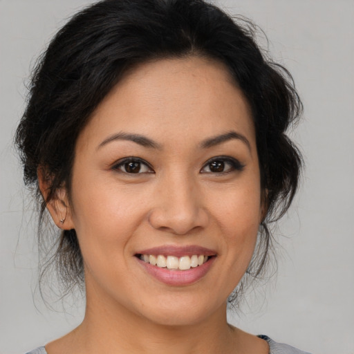 Joyful latino young-adult female with medium  brown hair and brown eyes