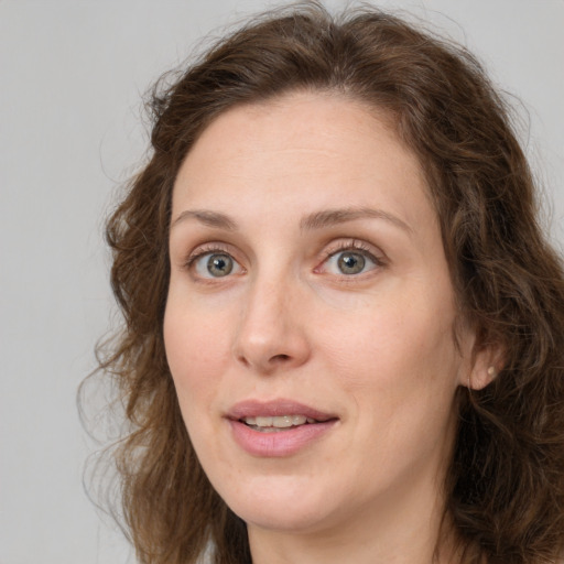 Joyful white adult female with long  brown hair and grey eyes