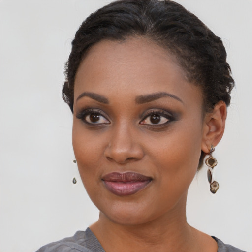 Joyful black young-adult female with short  brown hair and brown eyes