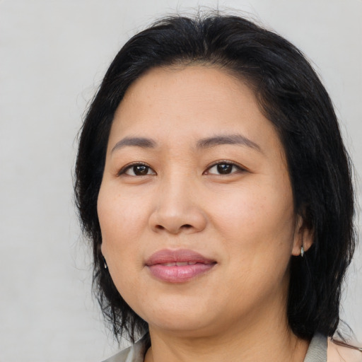 Joyful asian adult female with medium  black hair and brown eyes