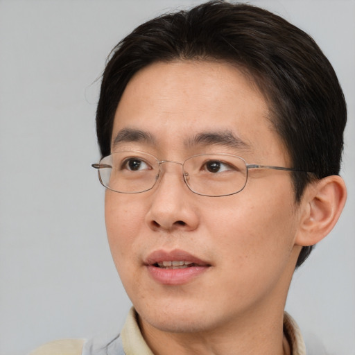 Joyful asian young-adult male with short  brown hair and brown eyes