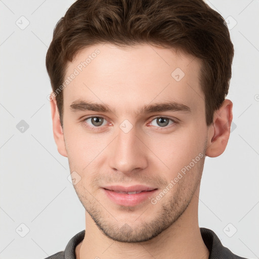 Joyful white young-adult male with short  brown hair and grey eyes