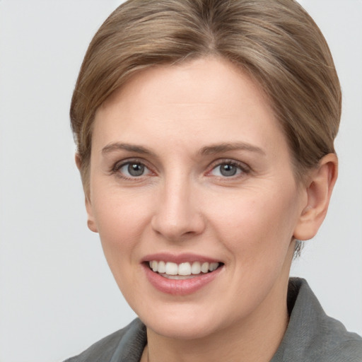 Joyful white young-adult female with short  brown hair and grey eyes