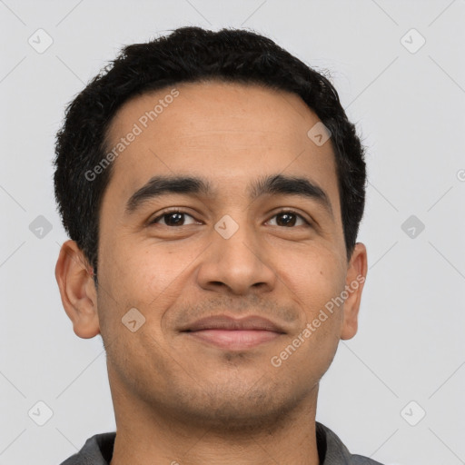 Joyful latino young-adult male with short  black hair and brown eyes