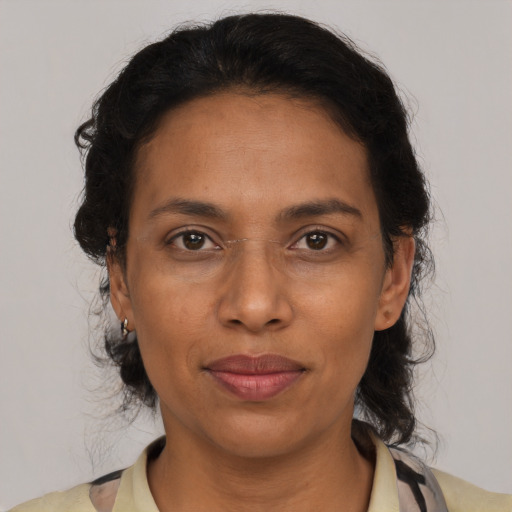 Joyful latino adult female with medium  brown hair and brown eyes