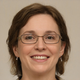 Joyful white adult female with medium  brown hair and green eyes