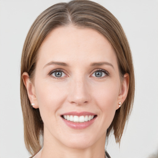 Joyful white young-adult female with medium  brown hair and grey eyes