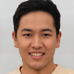 Joyful latino young-adult male with short  brown hair and brown eyes