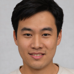 Joyful asian young-adult male with short  black hair and brown eyes