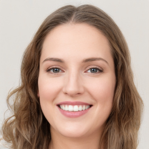 Joyful white young-adult female with long  brown hair and green eyes