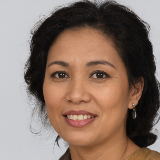Joyful latino adult female with long  brown hair and brown eyes