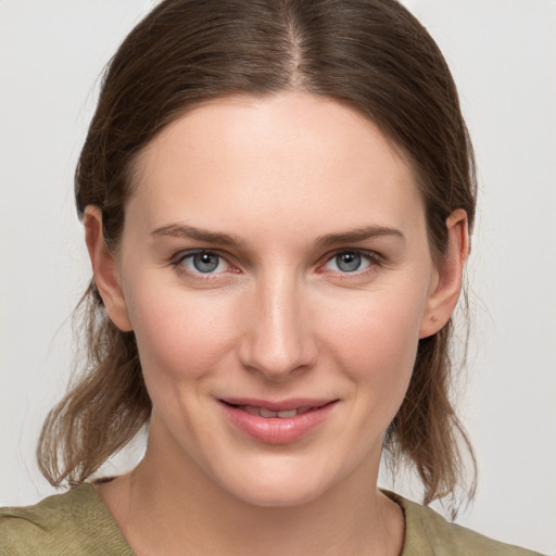 Joyful white young-adult female with medium  brown hair and grey eyes