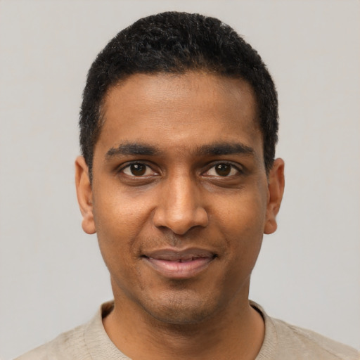Joyful black young-adult male with short  black hair and brown eyes
