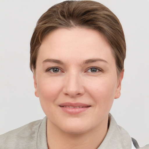 Joyful white young-adult female with short  brown hair and grey eyes