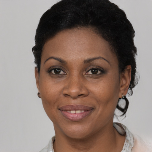 Joyful black young-adult female with short  brown hair and brown eyes