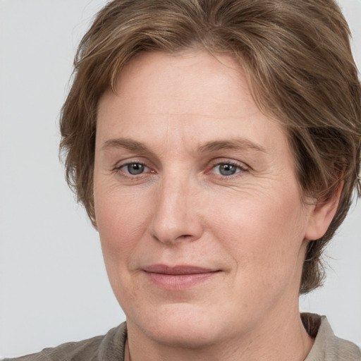 Joyful white adult female with medium  brown hair and grey eyes