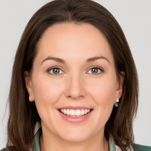 Joyful white young-adult female with medium  brown hair and grey eyes