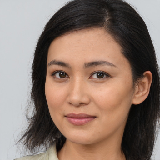 Joyful asian young-adult female with long  brown hair and brown eyes