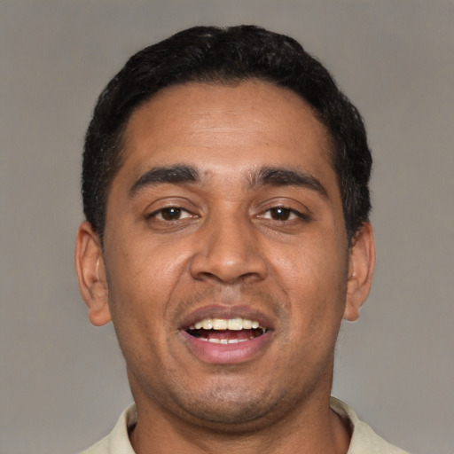 Joyful black young-adult male with short  black hair and brown eyes