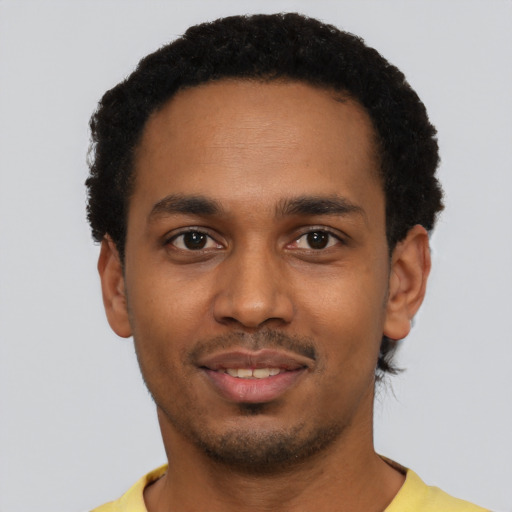 Joyful black young-adult male with short  black hair and brown eyes