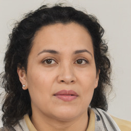 Joyful latino adult female with medium  brown hair and brown eyes