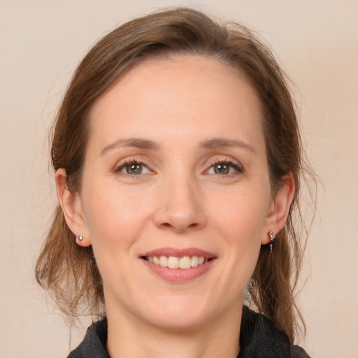 Joyful white adult female with medium  brown hair and grey eyes