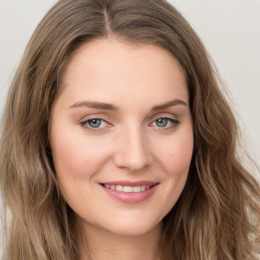 Joyful white young-adult female with long  brown hair and green eyes