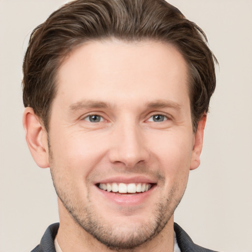 Joyful white young-adult male with short  brown hair and grey eyes