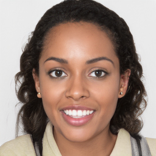 Joyful black young-adult female with long  brown hair and brown eyes